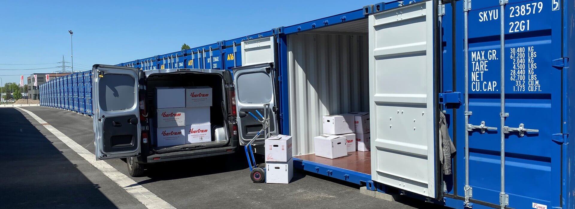 Umzugskartons vor Lagercontainern beim Einladen